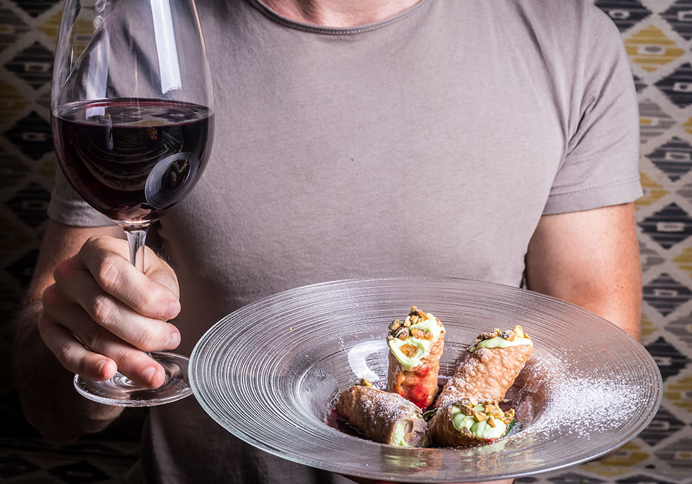 בחור מחזיק צלחת עם קנלוני לקינוח